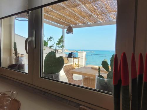 a view of the ocean from a kitchen window at La Terrazza sul Faro in Porto Empedocle