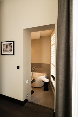 a bathroom with a bath tub and a sink at Boutique Hotel Beaumont Maastricht in Maastricht