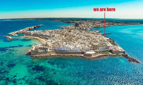 an island in the ocean with a sign that says we are here at Pantabrì - Casa Tipica su Mare nel Centro Storico di Gallipoli in Gallipoli