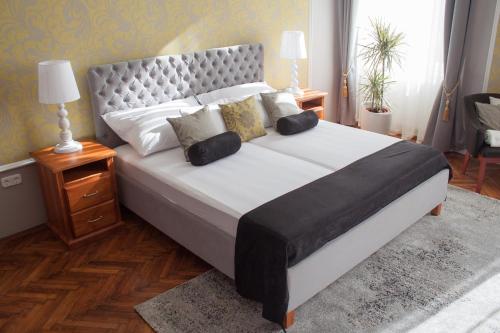 a bedroom with a large bed with a large headboard at Villa Apartman in Sárvár