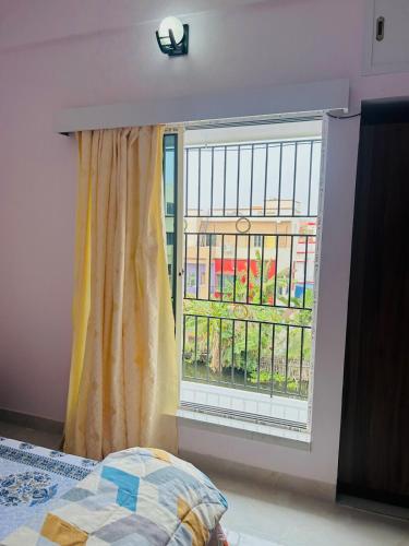 a window in a room with a bed next to it at Nest in fun in Kolkata