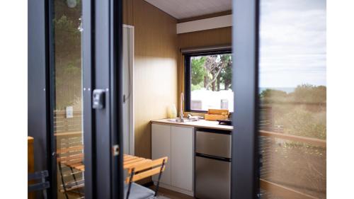 a small kitchen with a sink and a window at Pacific View by Tiny Away in Leithfield