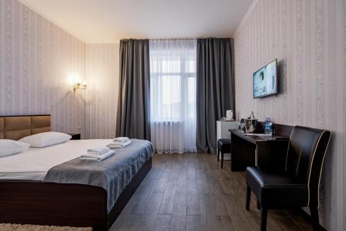 a hotel room with a bed and a desk at Hotel Verhovina in Kyiv