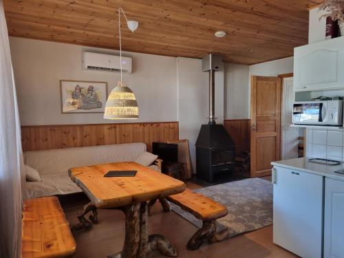 a living room with a table and a stove at Kaamasen Kievari in Kaamanen