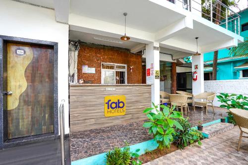 a restaurant with a sign on the side of a building at FabHotel Palm Inn Resort in Morjim