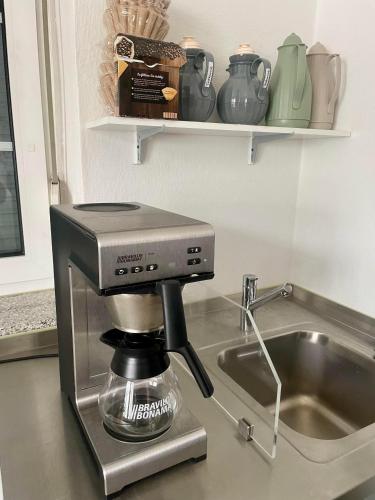 a coffee maker sitting on a counter next to a sink at Wohnen im Stielwerk in Munster
