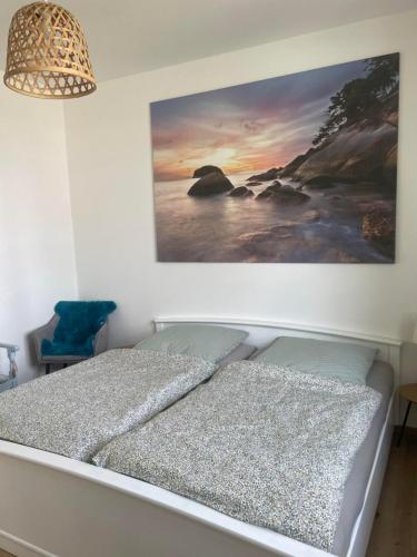 a bed in a bedroom with a painting on the wall at Wohnen im Stielwerk in Munster im Heidekreis