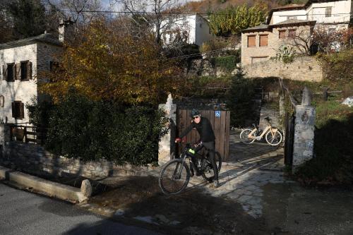 a person riding a bike next to a fence at Archontiko Michael since 1868 in Vizitsa