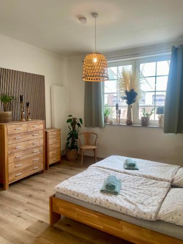 a bedroom with a large bed and a chandelier at Wohnen im Stielwerk in Munster