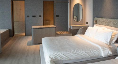 a bedroom with a white bed and a mirror at Sol Beach Namhae in Namhae