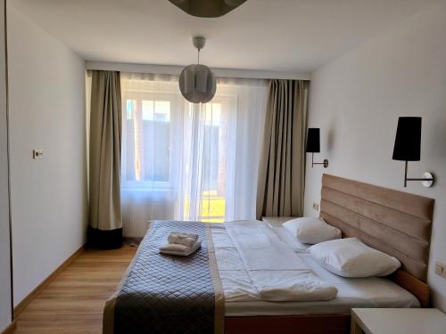 a bedroom with a large bed with a large window at Fala by Marena Wellness & Spa in Międzywodzie