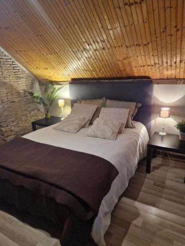 une chambre avec un grand lit avec un plafond en bois dans l'établissement Une nuit au domaine, à Saint-Léonard-en-Beauce