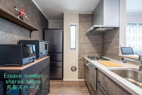 a kitchen with a sink and a refrigerator at Ici Japon Village in Tokyo