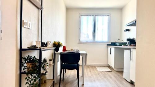 a small kitchen with a table and a chair at Le Fleural T2 Confort et Style Centre Muret in Muret