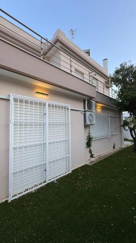 a white gate in the side of a house at Amazing villa with a magic view to the Aegean in Dhaskalión