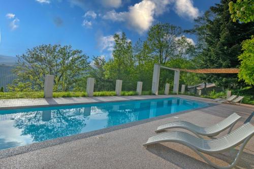 - une piscine avec une chaise blanche à côté dans l'établissement Peponi Classé 4 étoiles - Piscine - Parc des Monts d'Ardèche, à Gourdon
