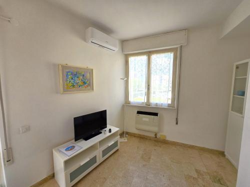 a living room with a flat screen tv on a wall at Appartamento Limen in Marinella di Sarzana