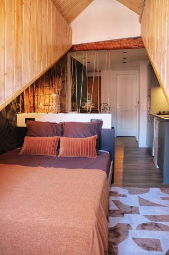 un grand lit dans une chambre aux murs en bois dans l'établissement Studio AUREA, à Annecy