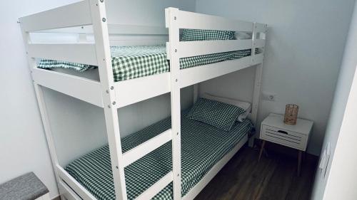 two white bunk beds in a small room at Casa en el centro , con amplia terraza in Vinarós