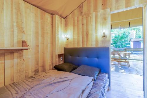 Ce lit se trouve dans un dortoir doté de murs en bois. dans l'établissement Tente Lodge 2 personnes, à Saint-Martial-de-Nabirat