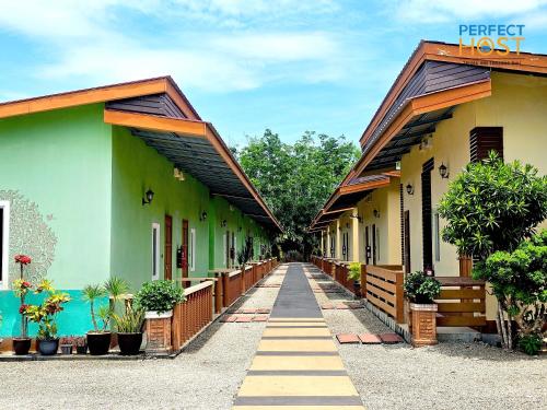 una fila di edifici verdi e gialli di Triima Inn Tanjung Rhu by Perfect Host ad Air Hangat