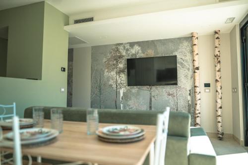 een eetkamer met een tafel en een televisie aan de muur bij Be Your Home - Il Piccolo Paradiso in Civitavecchia
