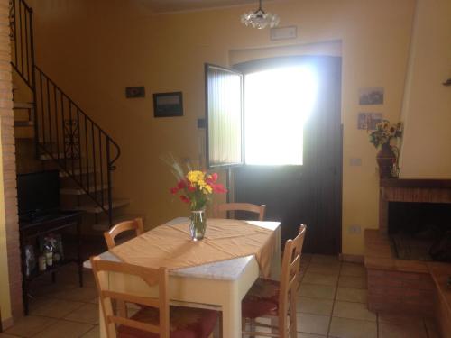 a dining room table with a vase of flowers on it at Agriturismo Villa Vetiche in Rocca San Giovanni