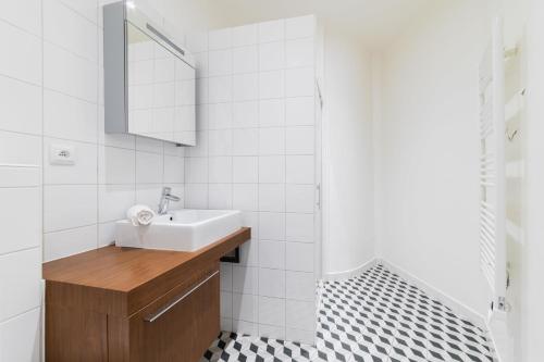 une salle de bain avec un lavabo et un miroir dans l'établissement Appartement cosy refait a neuf - Paris 19 - 4P, à Paris
