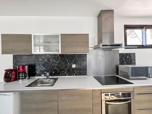 a kitchen with a sink and a microwave at Confort & calme à Bruay afin d'explorer le Nord in Bruay-la-Buissiere