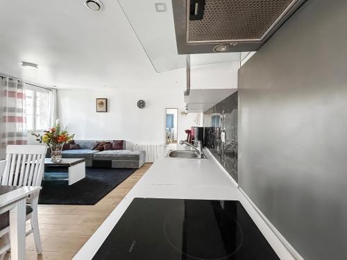a kitchen and living room with a couch and a table at Confort & calme à Bruay afin d'explorer le Nord in Bruay-la-Buissiere
