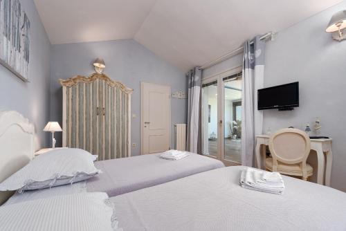 sypialnia z 2 łóżkami, telewizorem i biurkiem w obiekcie Villa Antea ZadarVillas w mieście Zadar