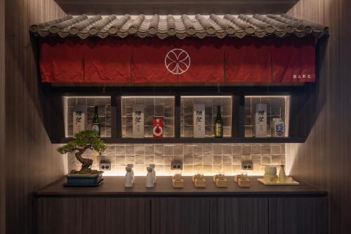 a room with a shelf with bottles and a plant at Koum Ryokan Hotel Gijang by Aank in Busan