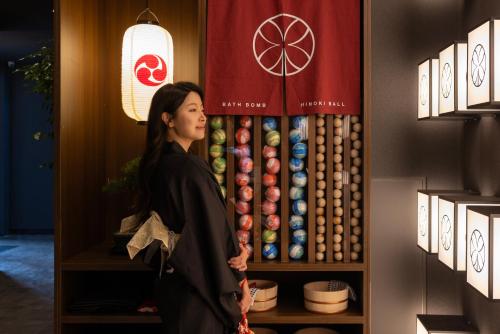 a woman standing in front of a display in a store at Koum Ryokan Hotel Gijang by Aank in Busan