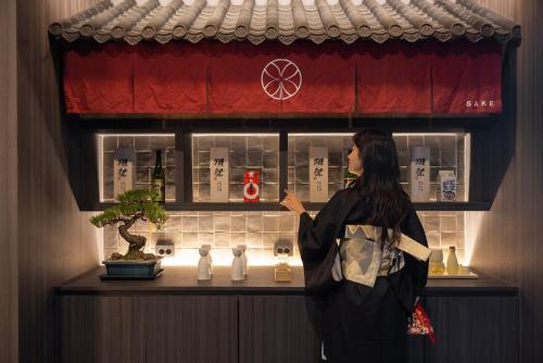 a woman standing in front of a sushi bar at Koum Ryokan Hotel Gijang by Aank in Busan