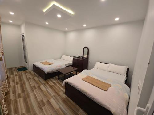 a hotel room with two beds and a table at Kailash villa and restro in Pokhara