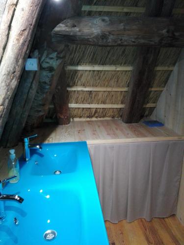 une salle de bain avec un lavabo bleu dans un grenier dans l'établissement La Chaumière aux Biches, à La Celle-sous-Gouzon