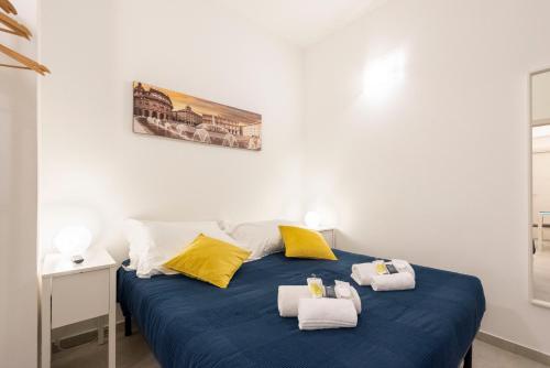 a bedroom with a blue bed with towels on it at Alla Casa Rosa al Mare, Central Seafront Stay, Air Conditioning, Wi-Fi, the Ideal Choice for a Relaxing and Exciting Coastal Escape, with available on request at 20,00 euro per night Private Garage, Welcome kit Priority, Prosecco and Canestrelli in Rapallo