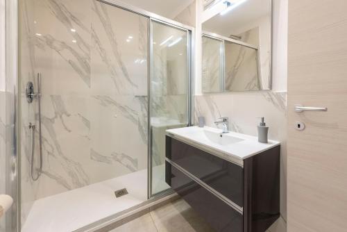 a bathroom with a sink and a shower at Alla Casa Rosa al Mare, Central Seafront Stay, Air Conditioning, Wi-Fi, the Ideal Choice for a Relaxing and Exciting Coastal Escape, with available on request at 20,00 euro per night Private Garage, Welcome kit Priority, Prosecco and Canestrelli in Rapallo