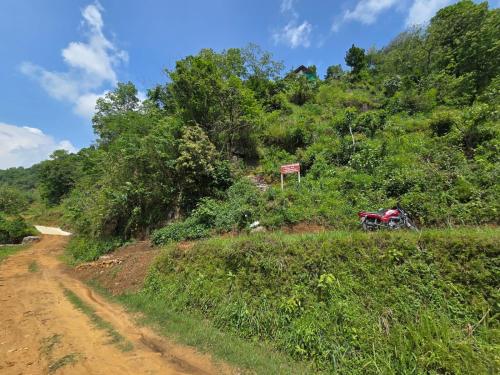 a dirt road with a motorcycle parked on a hill at Kailash villa and restro in Pokhara