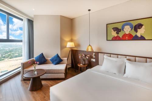a hotel room with a bed and a couch at Mandala Oceanfront Driftwood Resort in Phan Thiet