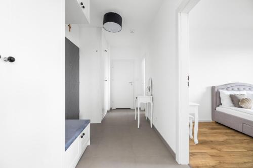 a white room with a bed and a table at Symphony Baltica Towers Apartamenty in Gdańsk