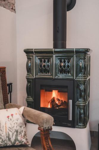a wood stove in a living room with a chair at Apartments Kienberg in Kienberg