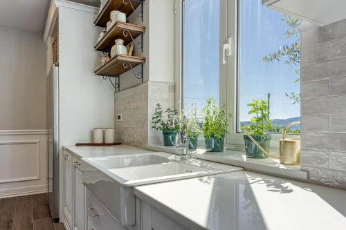 a kitchen with a sink and a window at VILLA PRISUNAC - private luxury with amazing sea view between Istria and Kvarner in Zagorje