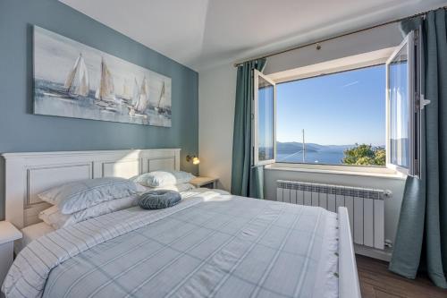 a bedroom with a bed and a large window at VILLA PRISUNAC - private luxury with amazing sea view between Istria and Kvarner in Zagorje