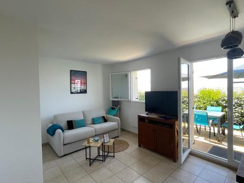 un soggiorno con un divano e una TV di Les terrasses de Pentrez - 11 a Saint-Nic