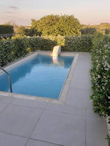a swimming pool in the middle of a garden at IO Luxury Pool & Hot Tub Suites in Preveza