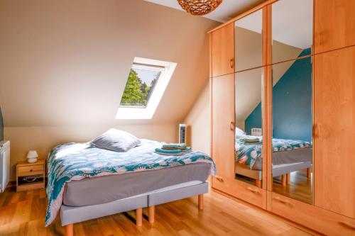 a bedroom with two beds and a mirror at Maison au milieu d'un parc arboré in Le Faouët