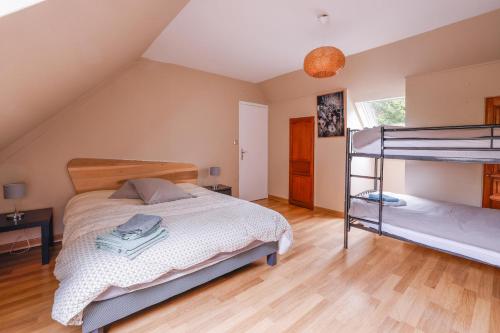 a bedroom with two bunk beds and wooden floors at Maison au milieu d'un parc arboré in Le Faouët
