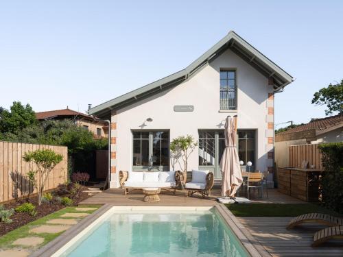 une maison avec une piscine dans la cour dans l'établissement Villas Couleurs Bassin, à Andernos-les-Bains