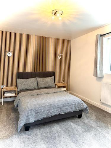 a bedroom with a bed and a striped wall at Cozy getaway in heart of warwick in Warwick